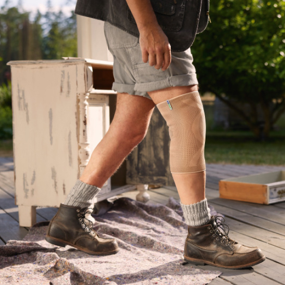 Hombre con pantalones cortos, botas y tobillera camina por el exterior junto a un mueble reformado. Hombre con pantalones cortos, botas y tobillera camina por el exterior junto a un mueble reformado.